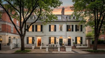 Symmetrical Georgian colonial-style house on a leafy New Jersey street at sunrise.